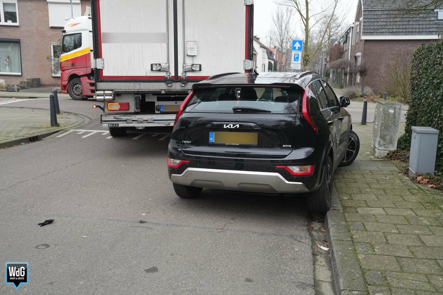 Draaiende vrachtwagen duwt geparkeerde auto de stoep op