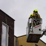 Brandweer verwijdert loshangende strip aan gevel in Nederweert