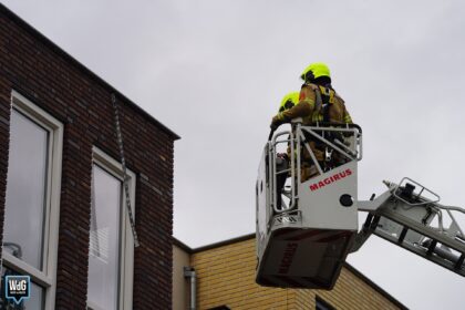 Brandweer verwijdert loshangende strip aan gevel in Nederweert
