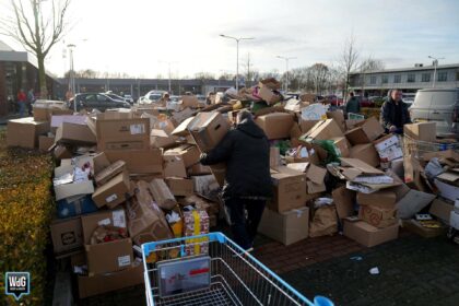 Metershoge papierstapel op Leuken door volle vuilniswagen