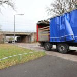 Vrachtwagen beschadigd na botsing tegen spoorviaduct