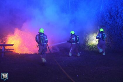 Brandweer blust brand in coniferenhaag aan Achtkantmolen