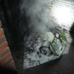 Poort en regenpijp beschadigd na brand afvalcontainer