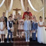De communicantjes van Leuken, Graswinkel en Keent samen met pastoor Ivo Krewinkel
