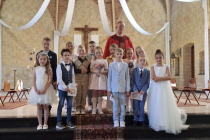 De communicantjes van Leuken, Graswinkel en Keent samen met pastoor Ivo Krewinkel