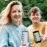 Twee mensen laten de natuurwaarnemingen app ObsIdentify op hun telefoon zien. Ingestuurde foto.