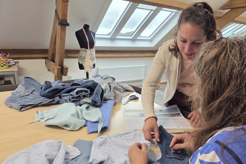 Twee deelnemers werken aan het wandkleed