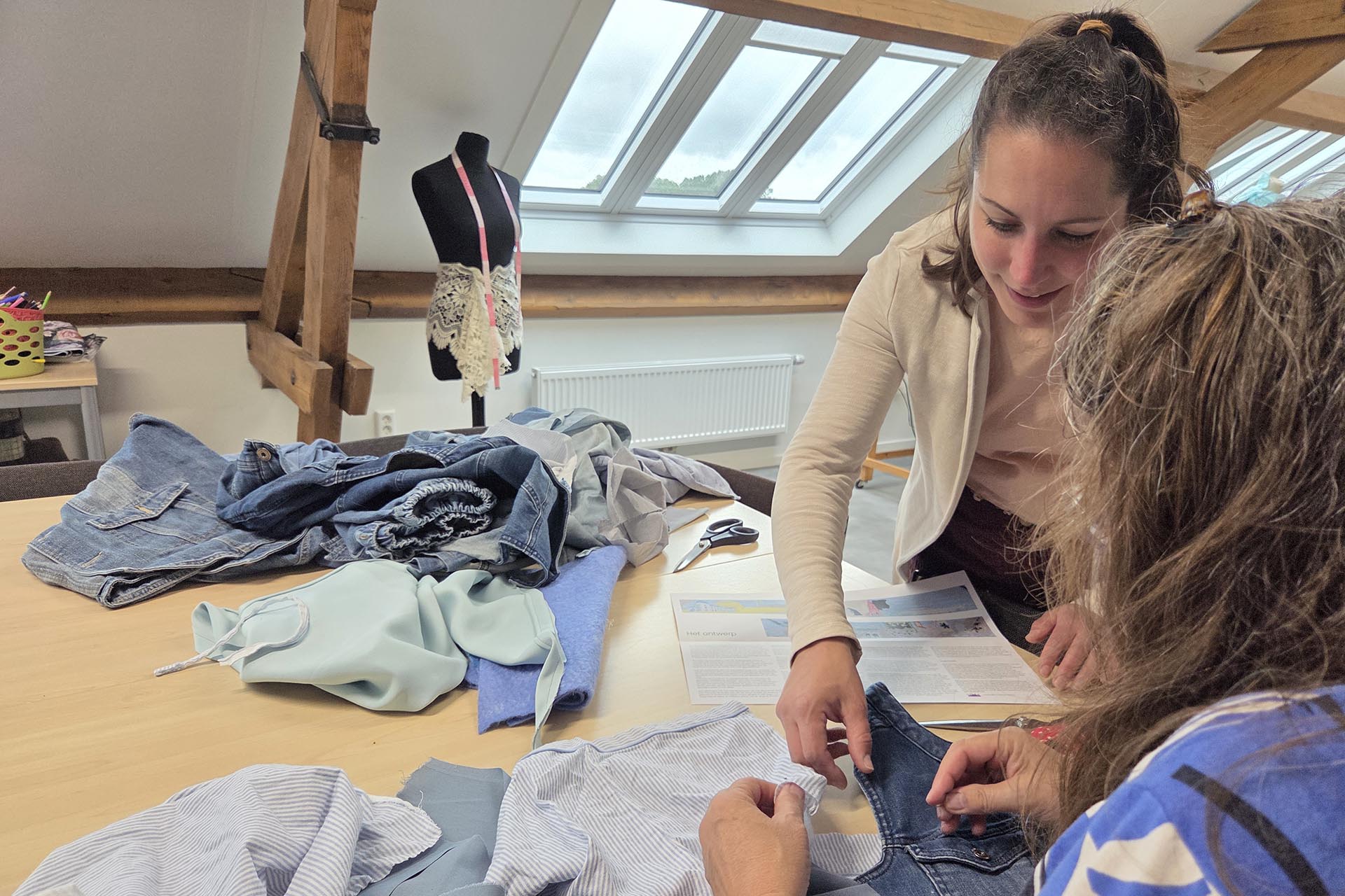 Twee deelnemers werken aan het wandkleed