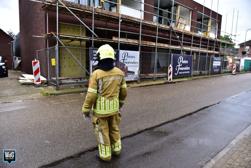 Bouwmaterialen waaien van steiger door stevige wind in Heythuysen