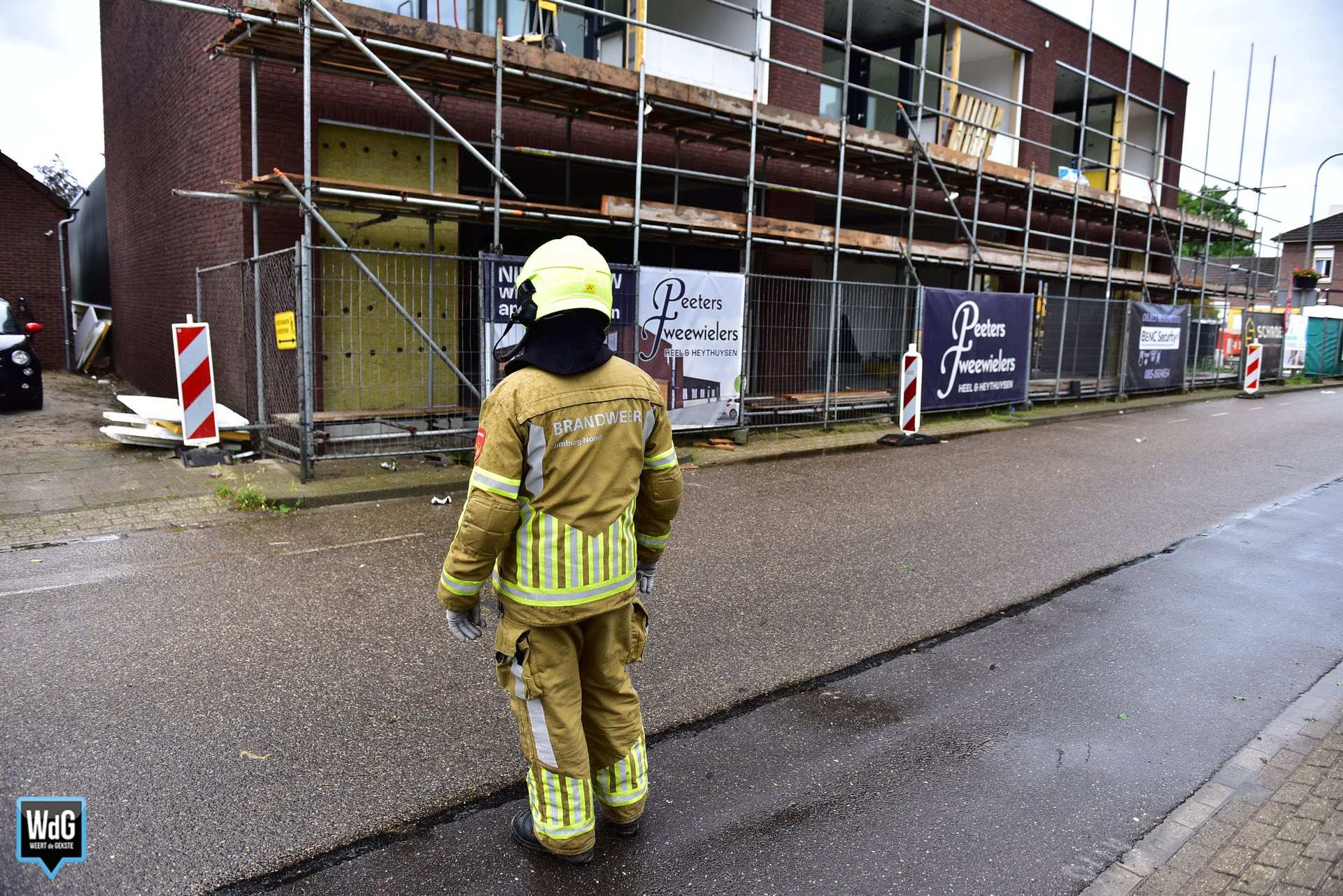 Bouwmaterialen waaien van steiger door stevige wind in Heythuysen