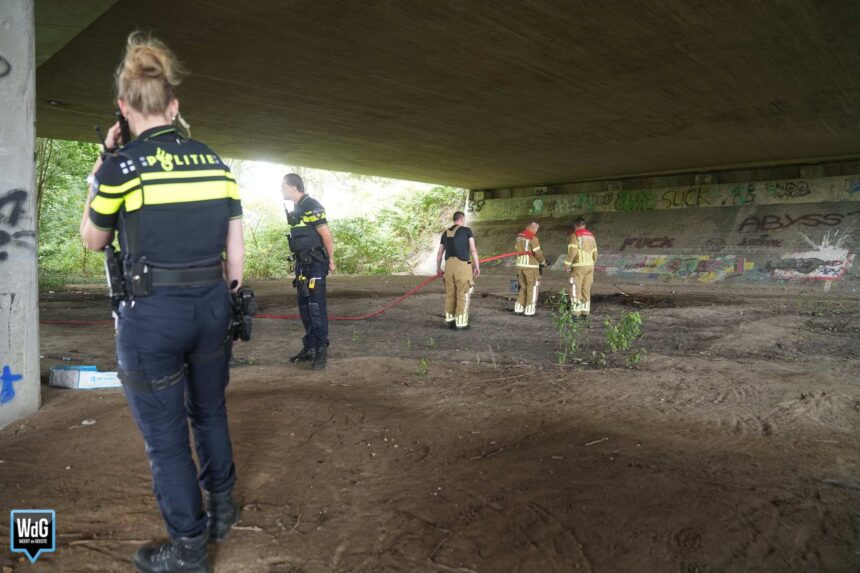 Brandweer blust kampvuur onder brug, man overgedragen aan crisisdienst