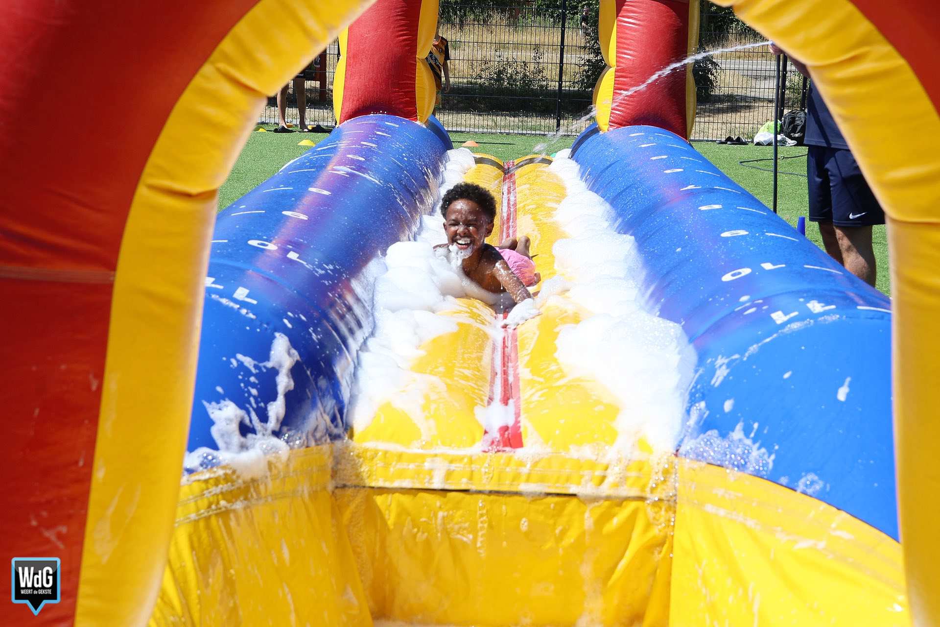 Tientallen jongeren genieten van buikschuiven op zomerdag
