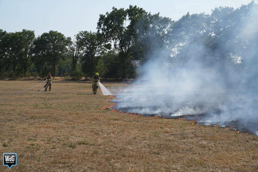 Brand op grasveld in Ell trekt richting bomenrij, strobalen en loods