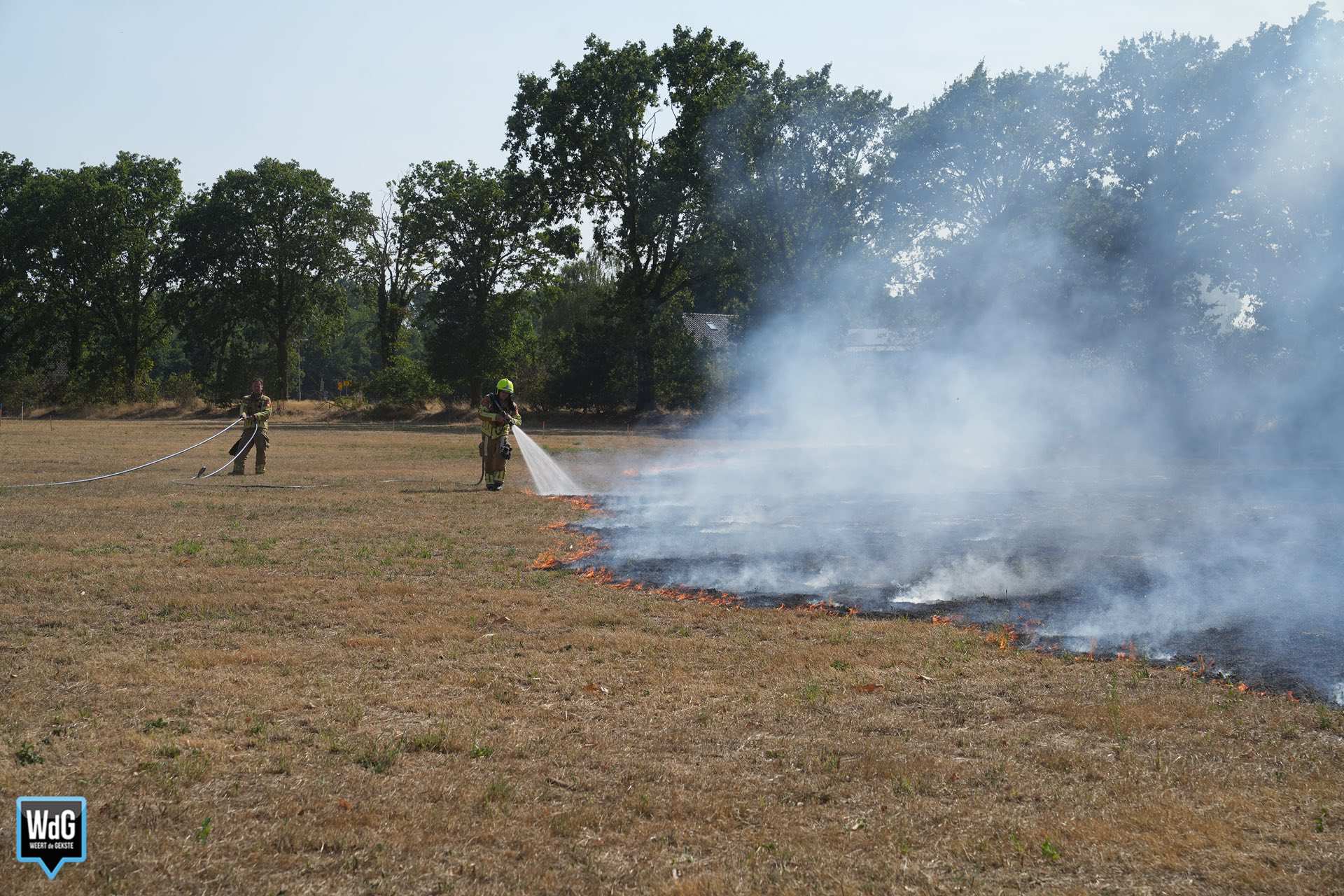 Brand op grasveld in Ell trekt richting bomenrij, strobalen en loods