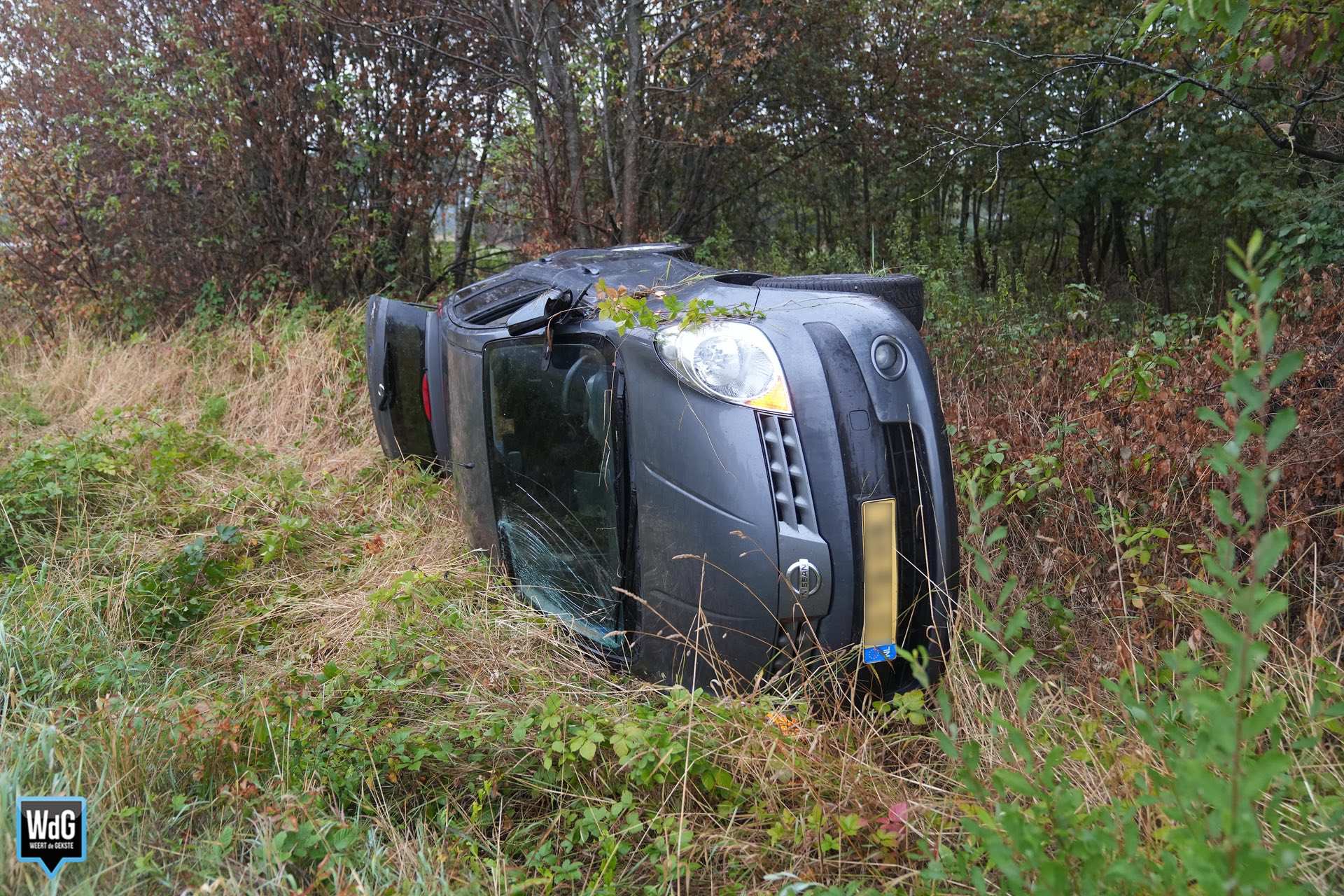 Auto belandt op zijkant in greppel langs Maaseikerweg