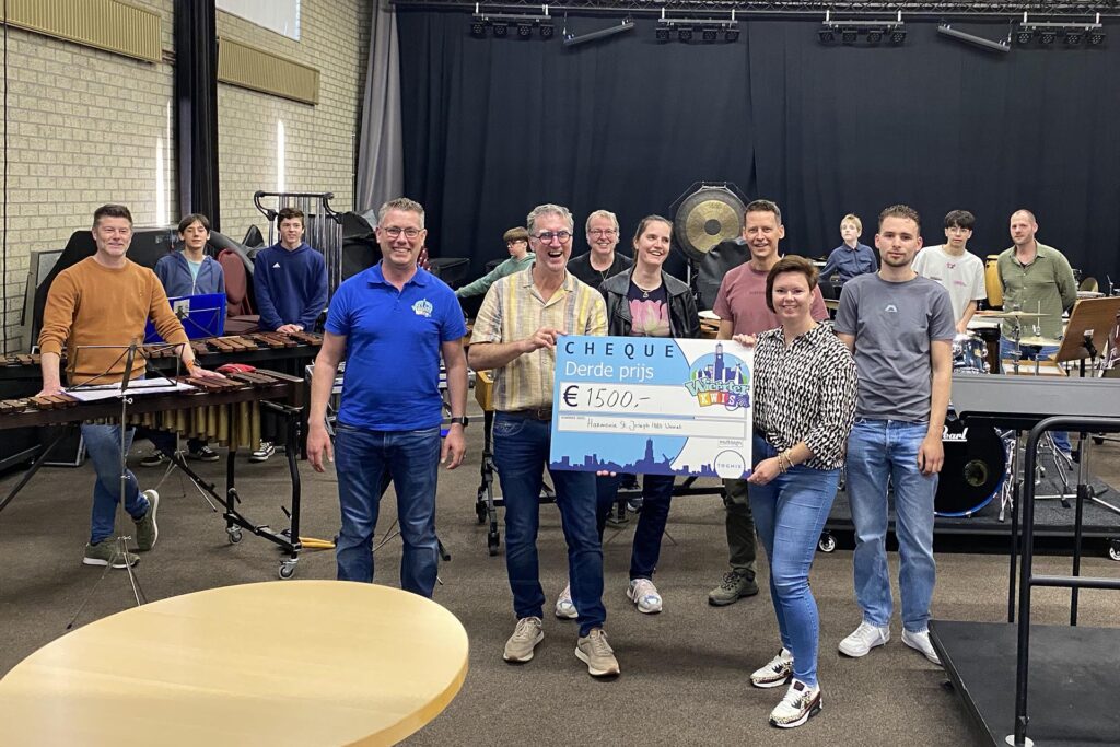 Het team van Harmonie St. Joseph 1880 overhandigt cheque aan het bestuur. Ingestuurde foto